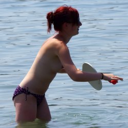 Рыжеволосая девушка топлесс на пляже 9